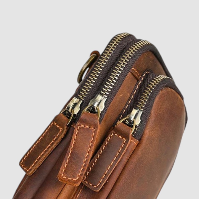 Detail šitia a kovových zipsov na kvalitnej koženej taške SAMUELSON